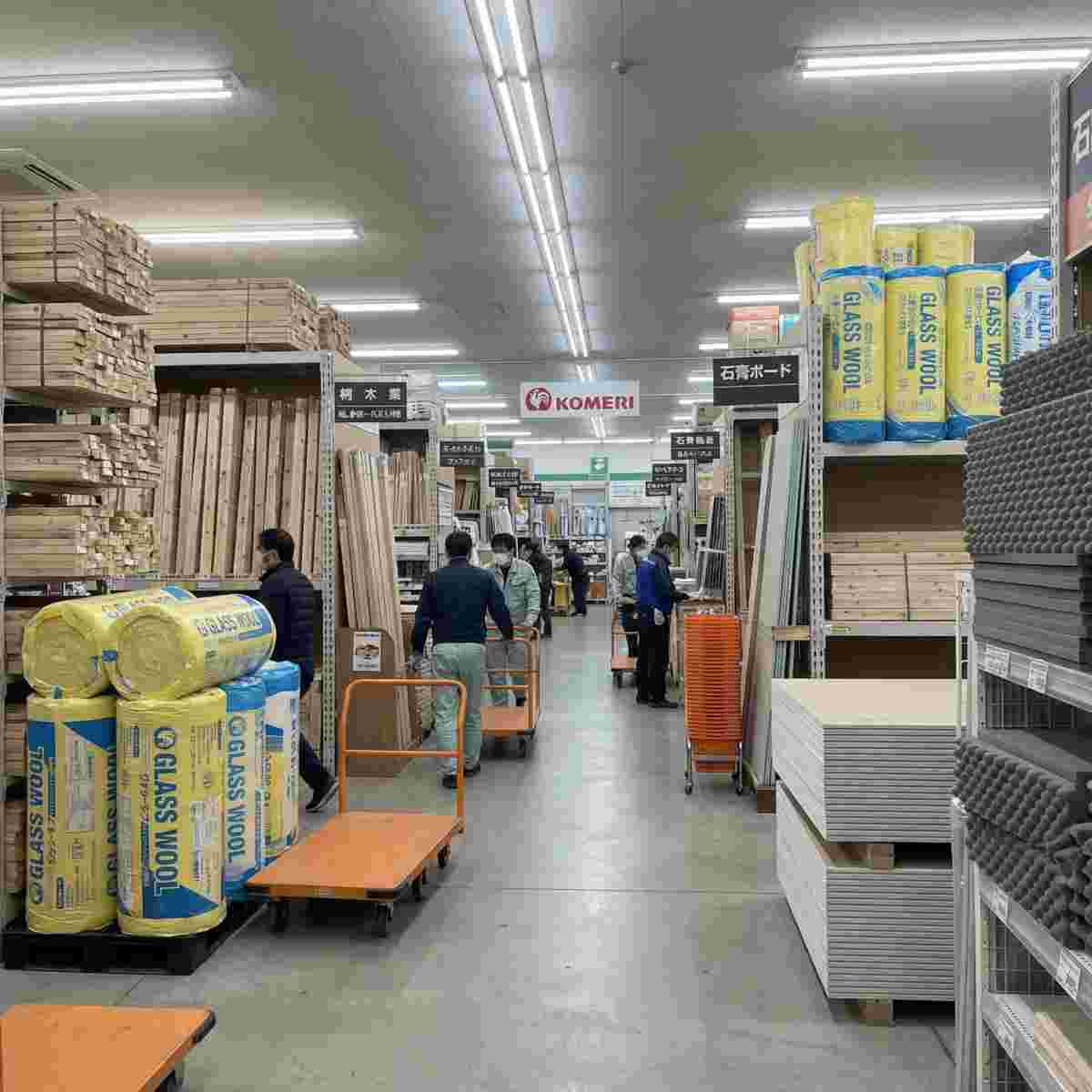 ホームセンターの建材売り場に並ぶグラスウール・石膏ボード・木材などの防音材料