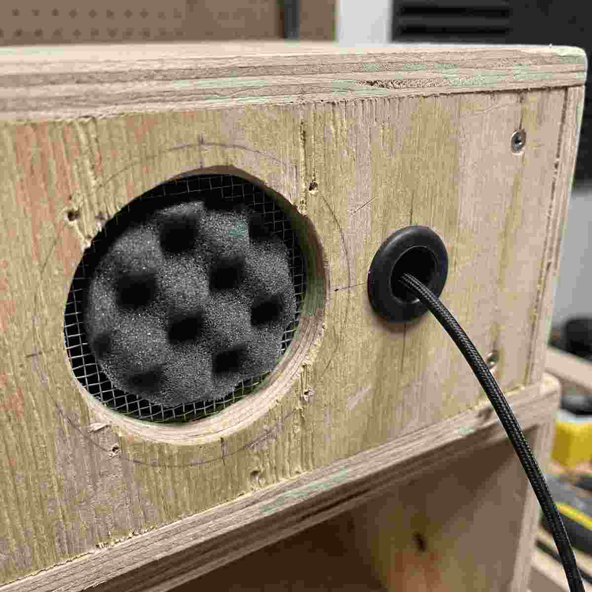 自作木製防音ボックスの側面パネルに設けた吸音フォーム付き換気穴とXLRケーブル用グロメット穴のクローズアップ